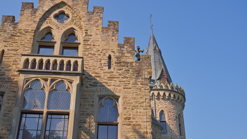 Closeup exterior detail of an elegant medieval castle and tower on a cloudless day with parallax tracking movement, Germany