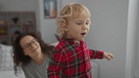Woman with curly hair watches young boy in red plaid shirt play in a cozy bedroom setting filled with bookshelves and decorations, capturing a moment of joyful interaction. - Powered by Shutterstock - Get 15% off with code: PIKWIZARD15