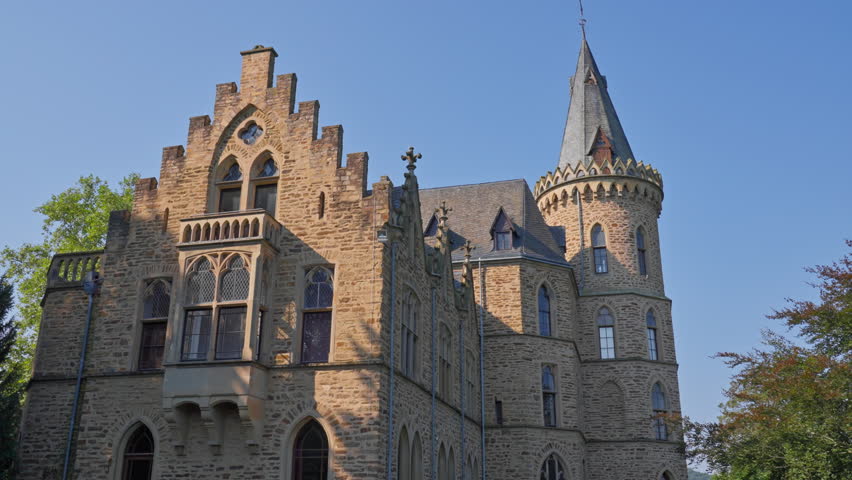 Exterior detail of an elegant medieval castle and tower on a cloudless day with parallax tracking movement, Germany