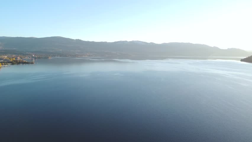 Panorama of Kelowna, BC, Canada. Downtown Waterfront Beach Pan to Bridge. British Columbia Summer Sunset. Calm Okanagan Lake. City Park Beach. City Skyline Condo Apartment Building Development