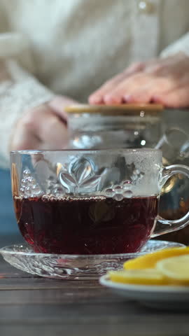 Vertical video. Tea time. Morning routine. Woman having breakfast with cup of tea. 