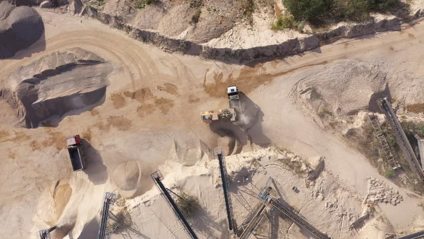 Aerial view of stone quarry conveyor belt system in operation, stone jaw crusher plant