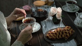 Tea time. Woman having morning breakfast with cup of tea and fresh pastries in cozy kitchen. - Powered by Shutterstock - Get 15% off with code: PIKWIZARD15