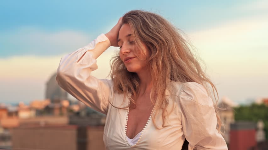 Caucasian woman in sunglasses posing with view of Barcelona on the background, Spain. Sunset