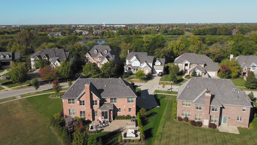 Aerial View of Suburban Neighborhood with Lake and Trees, A village in the state of Illinois in the United States