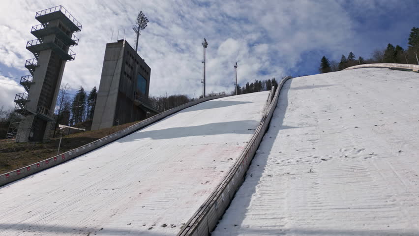 Jumper during training on ski jump Planica, a popular winter sports area in Slovenia with a chairlift near Kranjska Gora, drone shot.