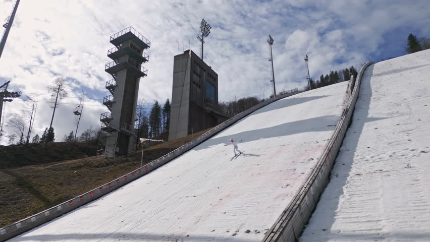 Jumper during training on ski jump Planica, a popular winter sports area in Slovenia with a chairlift near Kranjska Gora, drone shot.