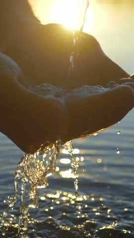clean water pouring into hands, vertical slow motion. clean drinking water, water splashing vertical video. environment, water crisis, pollution