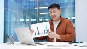 Professional asian male manager presenting chart data at workspace in the office. Businessman discussing growth statistics by video call using laptop. Business meeting, analysis, and teamwork concepts - Powered by Shutterstock - Get 15% off with code: PIKWIZARD15