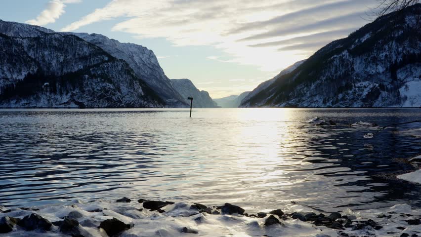 Beautiful winter sunset over Veafjord in Norway, with serene fjord waters and untouched snowy landscape