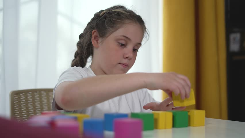 Child engaged in play with constructor blocks focused and creative. Kid's constructor playtime developing through building. Playful learning child with constructor in playroom. imaginative playtime.