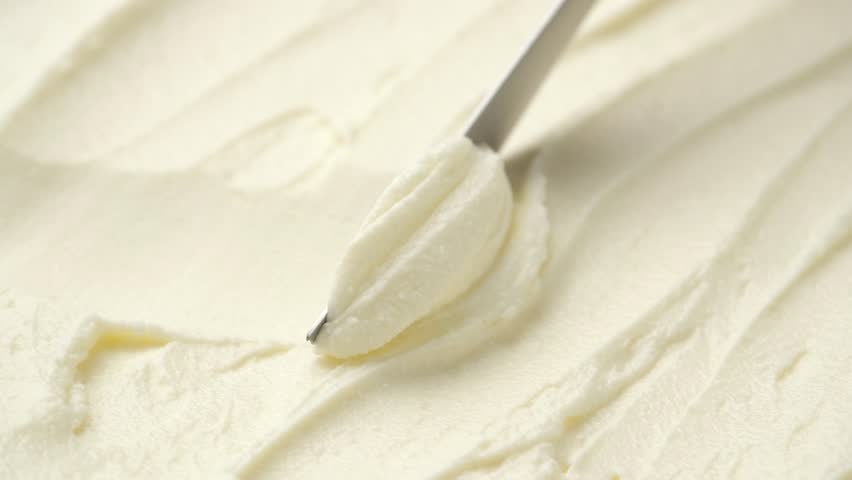 Close-up knife scooping natural cream cheese from package, concept video