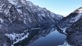 Aerial view of Klöntalersee in Glarus, Switzerland. Surrounded by snow-covered mountains, the pristine lake reflects the majestic alpine scenery, embodying the essence of winter tranquility. - Powered by Shutterstock - Get 15% off with code: PIKWIZARD15