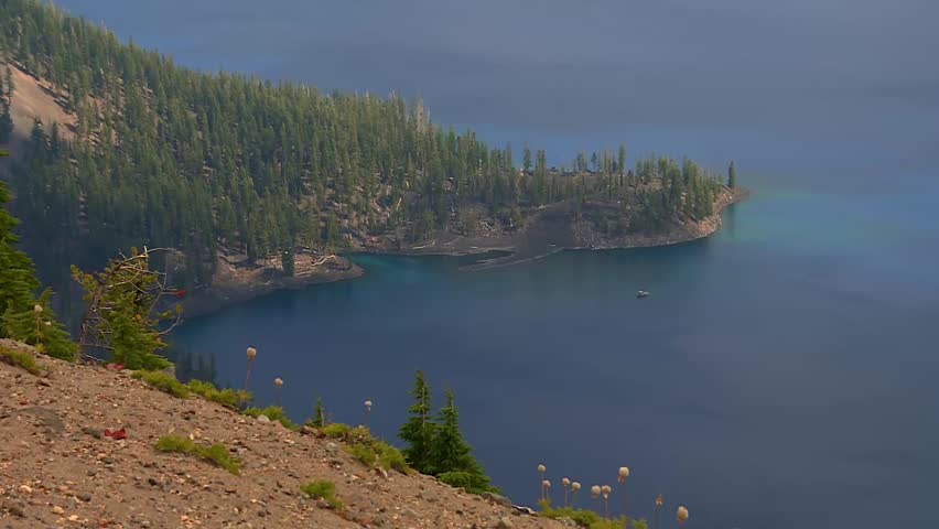 Static view of Crater Lake with forested shoreline and clear, deep blue water, USA.