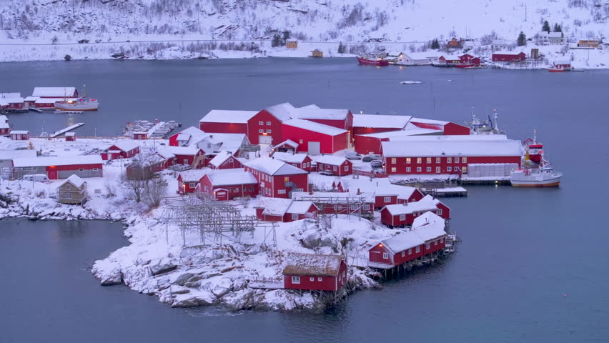 Calm waters of Hamnoy, a charming fishing village in Reine, Norway, with iconic red rorbu cabins surrounded by the snowy landscapes of the Lofoten Islands