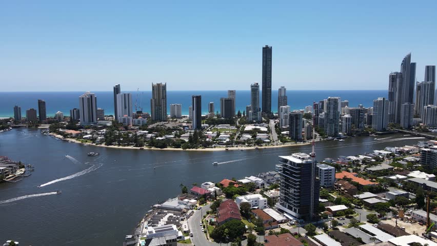 Panoramic view of the towering urban city skyline of the iconic Gold Coast with intertwining network of residential canal waterways. Creative drone view
