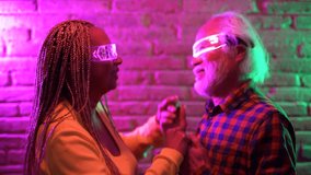 Happy elderly people dancing together wearing 3d metaverse goggles - Joyful senior couple having fun with futuristic technology  - Powered by Shutterstock - Get 15% off with code: PIKWIZARD15