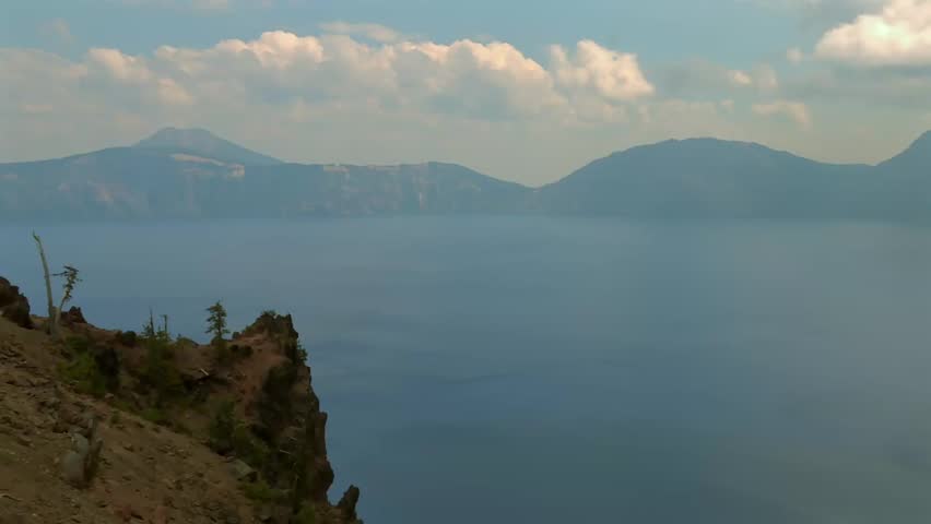 Garfield Peak towering above crater lake under a partially cloudy sky seen from the viewpoint