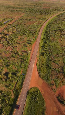Aerial view of winding road through arid landscape with beautiful greenery and vast terrain, Minilya, Australia.