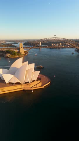 Aerial view of the iconic Sydney Opera House and harbor bridge at sunset with beautiful boats in the bay, Sydney, Australia.