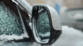 Close-up of a car mirror covered in snow with icicles with reflection of the car window , showing a blurred background of another snow-covered car in winter - Powered by Shutterstock - Get 15% off with code: PIKWIZARD15