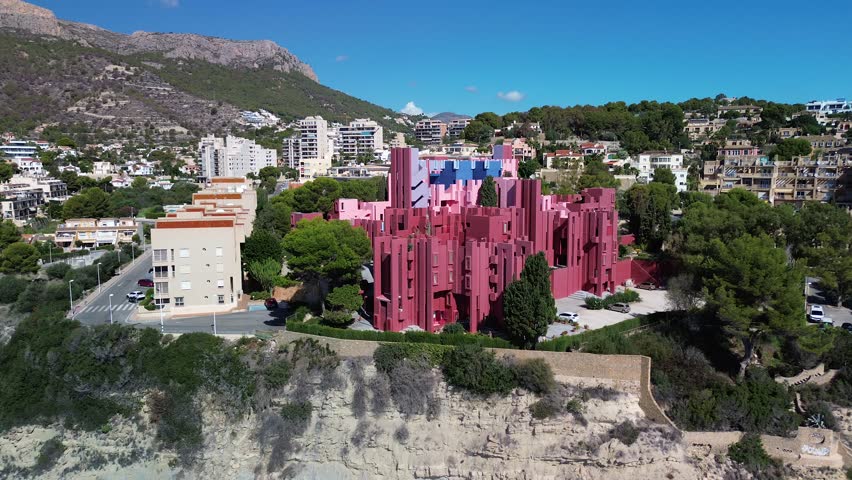 Aerial view of la muralla roja and coastal buildings with the sea and mountains, Calpe, Spain.