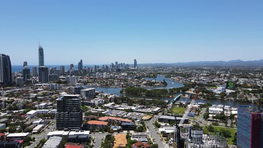 Towering urban city skyline of the iconic Gold Coast with intertwining network of residential canal waterways. Panoramic drone view