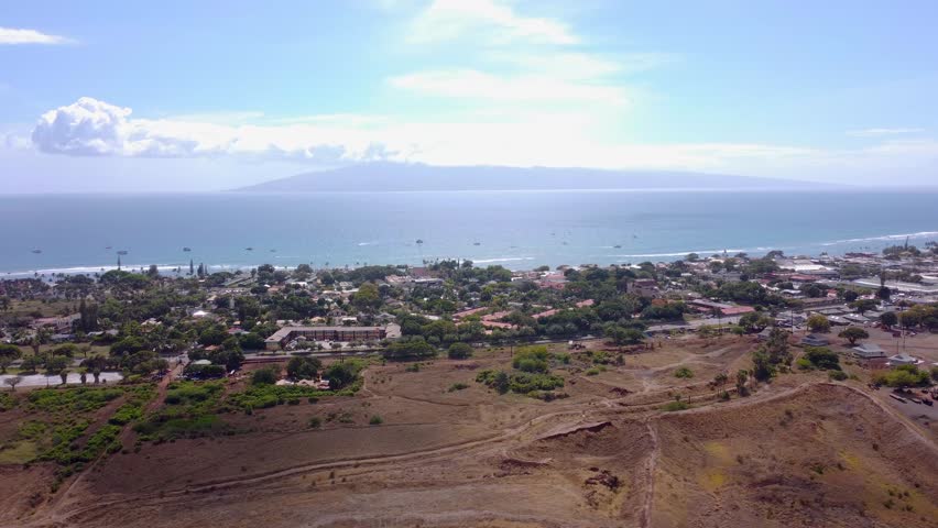 A aerial cinematic video of old town Lahaina and the tropical pacific ocean.