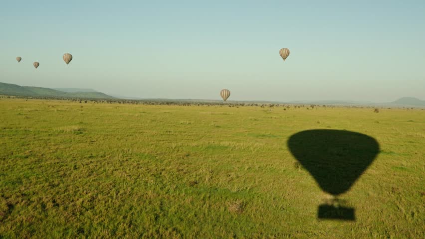 Shadow of hot air balloon slowly makes its way over the Serengeti