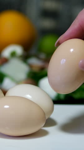 Close-up of female hands peels boiled egg. Peeling eggs from the shell. Cooking dinner or salad with boiled eggs