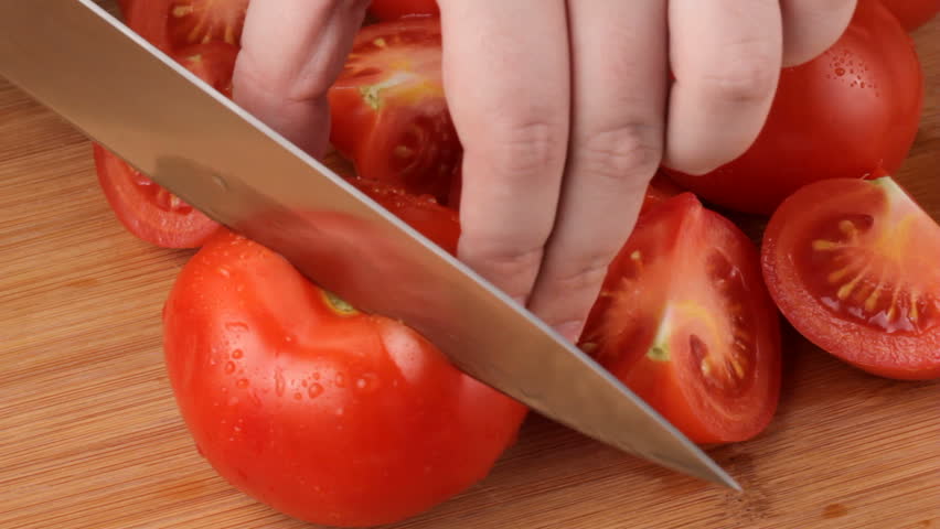 Cutting red ripe tomatoes, shot in HD video