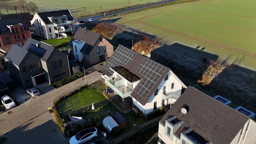 Modern one family homes with solar panels on roof. Rural area and new developed housing. Area in suburb. Aerial top down backwards. United States of America theme.