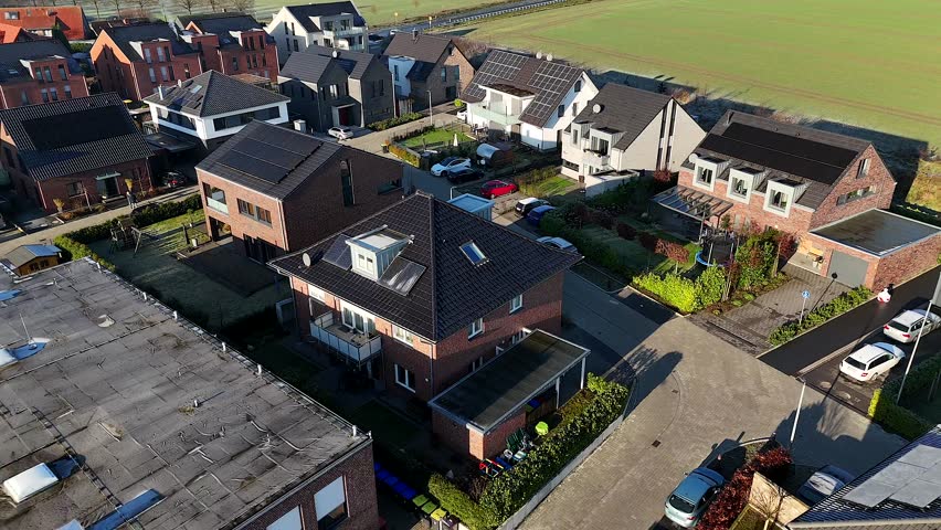Modern one family homes with solar panels on roof. Rural area and new developed housing. Area in suburb. Aerial top down backwards. United States of America theme.