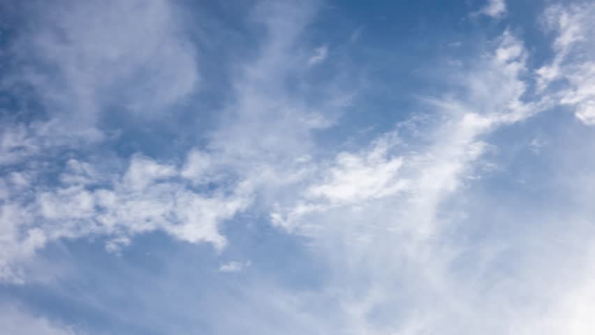 White clouds moving fast from right to left time-lapse. Daylight cloudy heaven background. Long timelapse light clouds transforming in blue sky with motion blur. Perfect for text, titles, logo