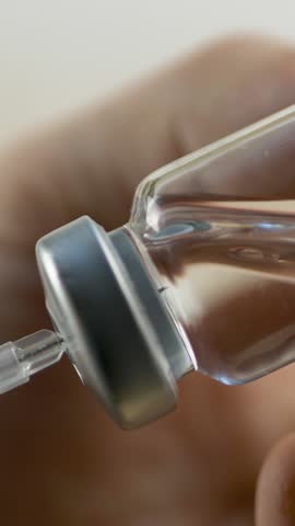 Medical hand extracts liquid medication from vial into syringe. Sterile handling for safe drug administration. Healthcare industry. Hospital procedures. Professional approach in patient care 