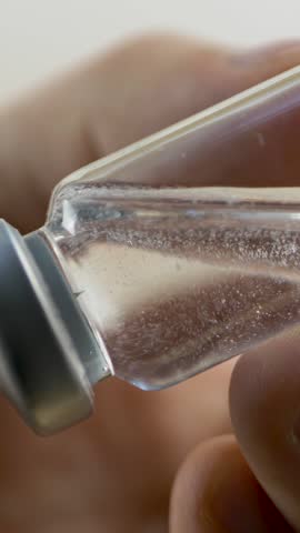 Medical hand extracts liquid medication from vial into syringe. Sterile handling for safe drug administration. Healthcare industry. Hospital procedures. Professional approach in patient care 