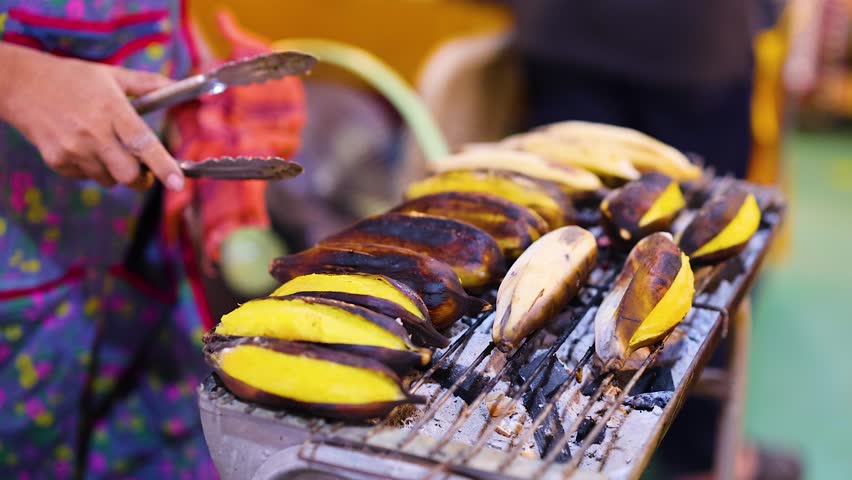 Vendor grilling bananas with sweet coconut sauce