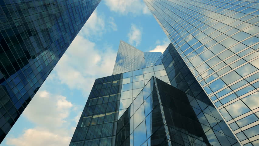 Glass skyscrapers in urban cityscape reflect sky, creating futuristic corporate setting