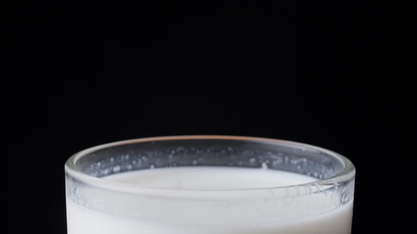 Hand Dipping A Chocolate Chip Cookie In A Cup Of Milk.