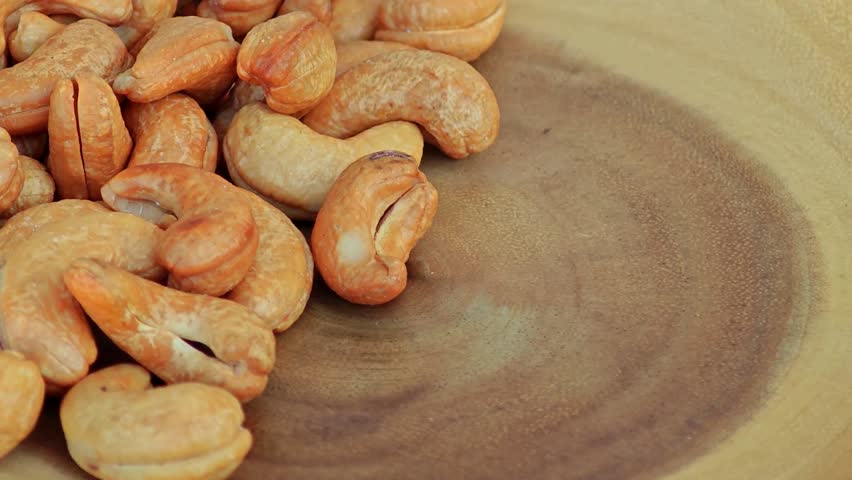 Roasted cashew nuts in wooden bowl.