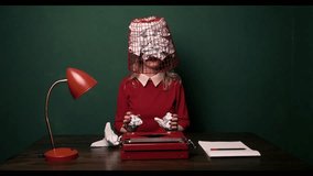 A white woman in a red dress works on a typewriter in an office with green walls. A wastepaper basket is on her head, symbolising burnout and workplace exhaustion - Powered by Shutterstock - Get 15% off with code: PIKWIZARD15