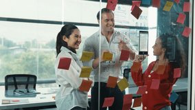 Happy professional business team brainstorming marketing idea by using colorful sticky notes to share creative idea at glass wall. Group of diverse business team discuss about strategy. Manipulator. - Powered by Shutterstock - Get 15% off with code: PIKWIZARD15