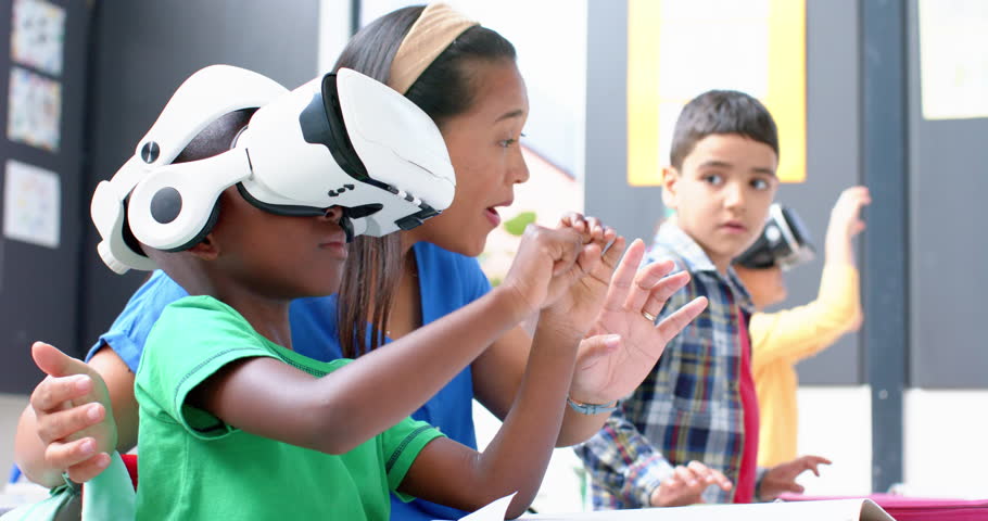 In school, boy using VR headset while teacher and classmate watching attentively. Education, technology, virtual reality, classroom, learning, digital, unaltered, slow motion