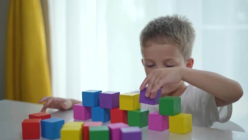 Kindergarten boy play with constructor blocks. Boy building with colorful blocks kindergarten. Creative play with constructor. childhood development with block constructor. Boy engaged learning blocks