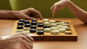 Daughter, playing white checkers, calmly wins against her father, capturing his pieces. Family game, strategy, logic. - Powered by Shutterstock - Get 15% off with code: PIKWIZARD15