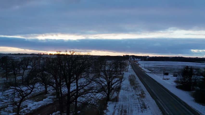 Rural Iowa Winter Blizzard Landscape at Sunset: 4K Drone Footage of Snow-Covered Fields and Farmland in the USA from a Birds-Eye View