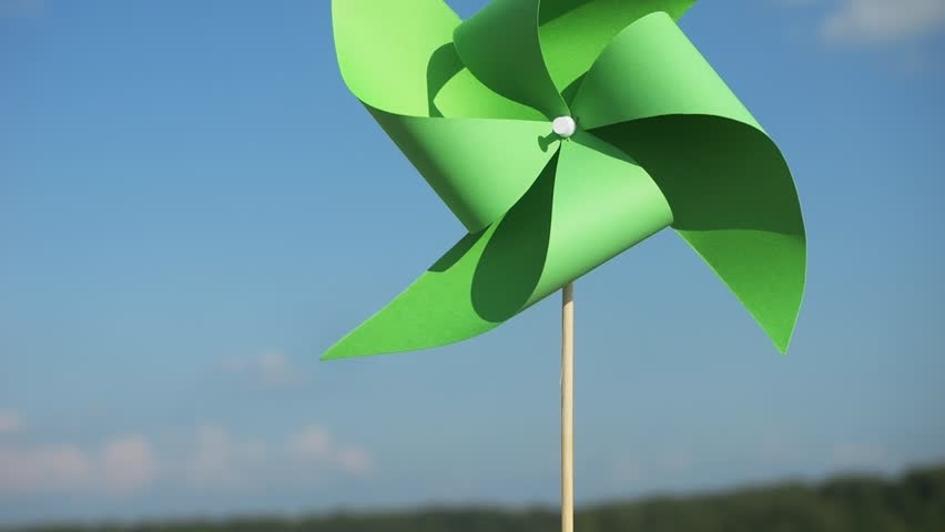 renewable energy concept vertical video. green paper pinwheel in hands against blue sky. World Environment Day. Recycling symbol. circular economy concept for environmental sustainability 