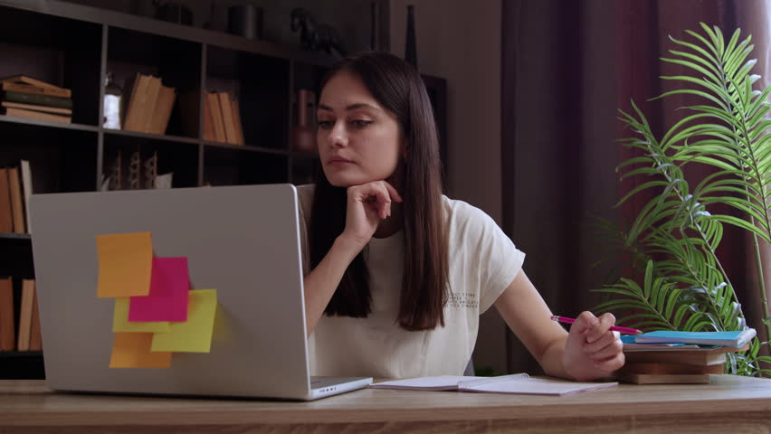 Young adult businesswoman professional marketing manager using laptop. Businesswoman working on digital data management on computer sitting at workplace in large modern corporate office.