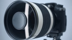 A professional camera on a tripod with a powerful mirror zoom lens that reflects the light of lamp. Closeup. Macro - Powered by Shutterstock - Get 15% off with code: PIKWIZARD15