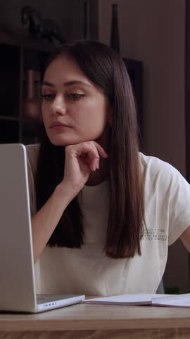 Young adult businesswoman professional marketing manager using laptop. Businesswoman working on digital data management on computer sitting at workplace in large modern corporate office.